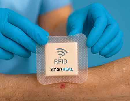 Enfermera aplicando un apósito inteligente con sensor RFID en el antebrazo de un pacient
